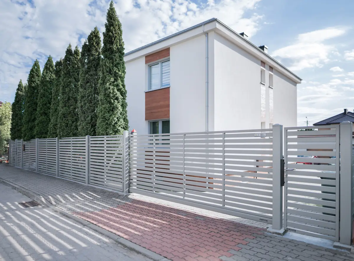 Recinzione moderna in ferro su misura per villa, coordinata con il cancello elettrico scorrevole e progettata da Effedi a Bergamo e provincia.